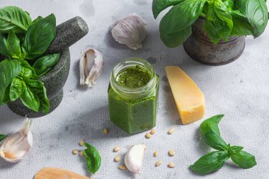 Masadaki cam kavanozda pesto sosu. Basil