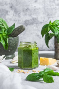 Masadaki cam kavanozda pesto sosu. Basil