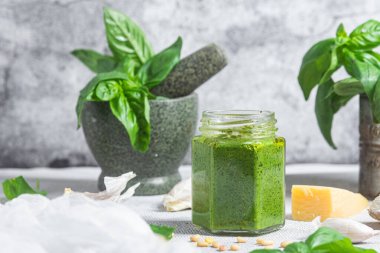 Masadaki cam kavanozda pesto sosu. Basil