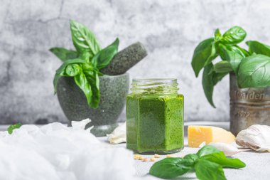 Masadaki cam kavanozda pesto sosu. Basil