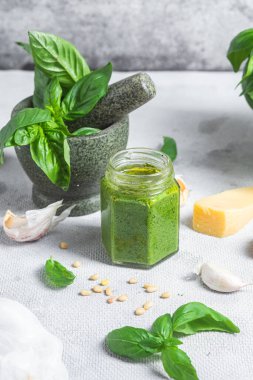 Masadaki cam kavanozda pesto sosu. Basil