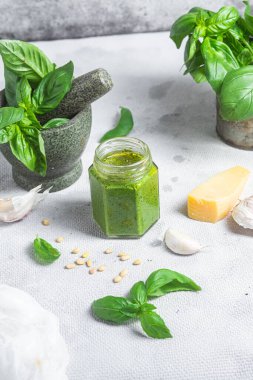 Masadaki cam kavanozda pesto sosu. Basil