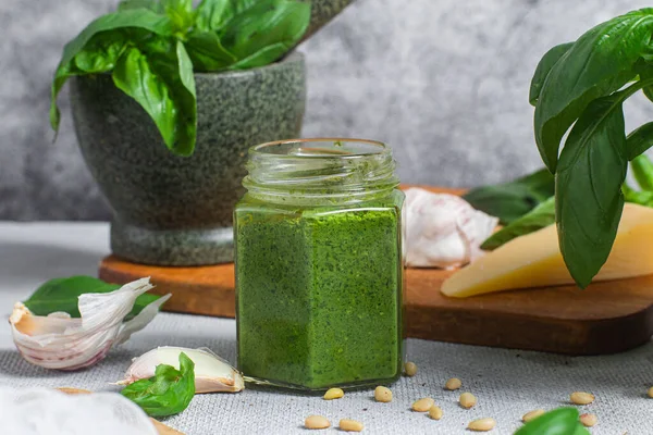 Masadaki cam kavanozda pesto sosu. Basil