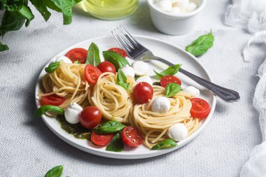 Mozzarella, domates, fesleğen ve pesto soslu spagetti. Makarna Kapsülü