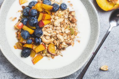 Yoğurtlu granola, şeftali, yaban mersini. 