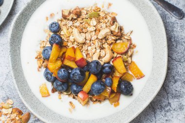 Yoğurtlu granola, şeftali, yaban mersini. 