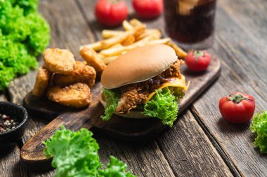 Çizburger, patates, tahtanın üstünde nugget.