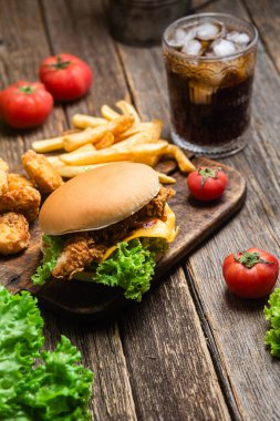 Çizburger, patates, tahtanın üstünde nugget.