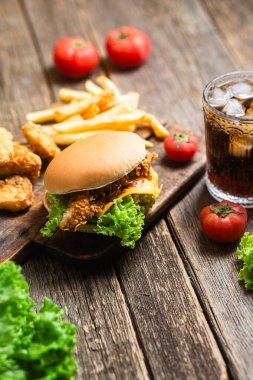 Çizburger, patates, tahtanın üstünde nugget.