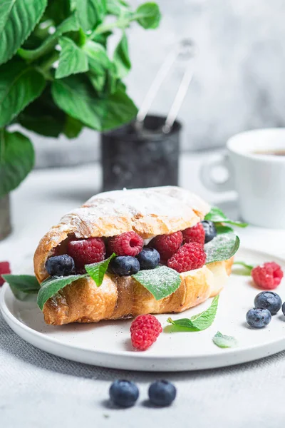 stock image Croissant with raspberries, blueberries and cream cheese on a white plate