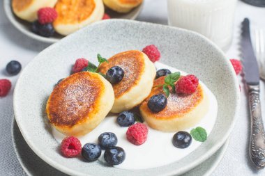 Krem soslu, ahududu ve yabanmersinli süzme peynirli krep.