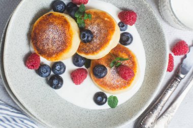 Krem soslu, ahududu ve yabanmersinli süzme peynirli krep.