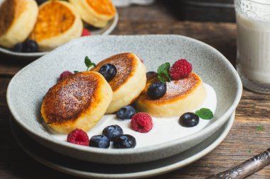 Krem soslu, ahududu ve yabanmersinli süzme peynirli krep.