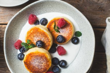 Krem soslu, ahududu ve yabanmersinli süzme peynirli krep.