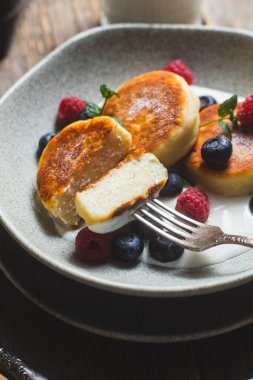 Krem soslu, ahududu ve yabanmersinli süzme peynirli krep.