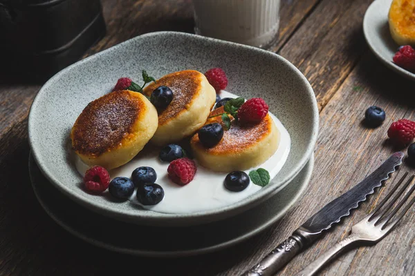 Stock image Cottage cheese pancakes with creamy sauce, raspberries and blueberries