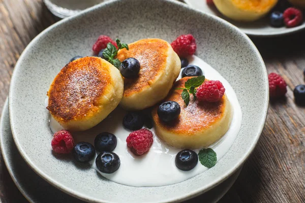 Stock image Cottage cheese pancakes with creamy sauce, raspberries and blueberries