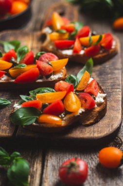 Sandwich with tomatoes, pesto and balsamic sauce on a wooden board