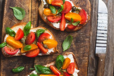 Sandwich with tomatoes, pesto and balsamic sauce on a wooden board