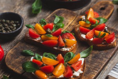 Sandwich with tomatoes, pesto and balsamic sauce on a wooden board