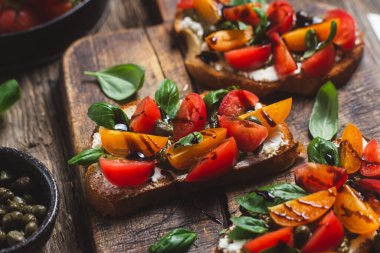 Sandwich with tomatoes, pesto and balsamic sauce on a wooden board
