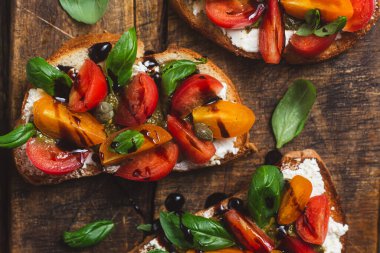 Sandwich with tomatoes, pesto and balsamic sauce on a wooden board