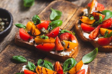 Sandwich with tomatoes, pesto and balsamic sauce on a wooden board