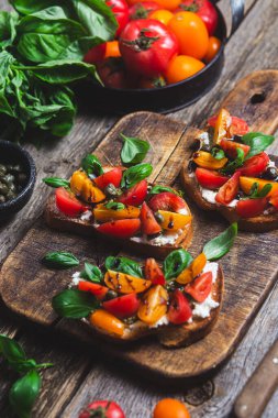 Sandwich with tomatoes, pesto and balsamic sauce on a wooden board