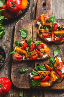 Sandwich with tomatoes, pesto and balsamic sauce on a wooden board