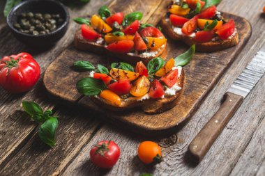 Sandwich with tomatoes, pesto and balsamic sauce on a wooden board