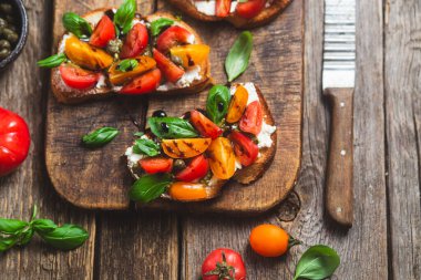 Sandwich with tomatoes, pesto and balsamic sauce on a wooden board