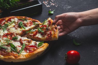 Jambonlu pizza, domates ve arka planda mozzarella.