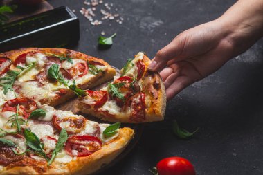 Jambonlu pizza, domates ve arka planda mozzarella.