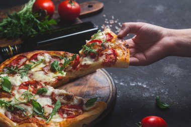 Jambonlu pizza, domates ve arka planda mozzarella.