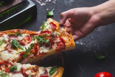 Jambonlu pizza, domates ve arka planda mozzarella.