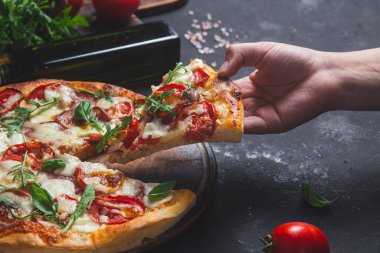 Jambonlu pizza, domates ve arka planda mozzarella.