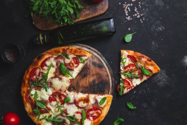 Jambonlu pizza, domates ve arka planda mozzarella.