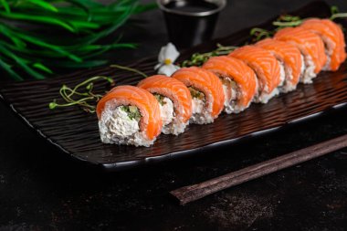 Çeşitli suşiler, koyu bir arka planda yuvarlanıyor.