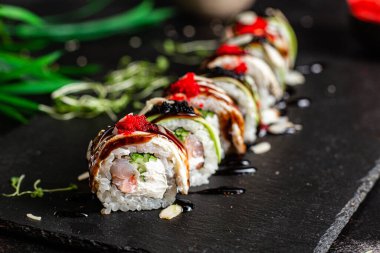 Çeşitli suşiler, koyu bir arka planda yuvarlanıyor.