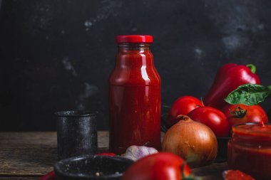 Kavanozda ketçap. Koyu arkaplanda domates sosu