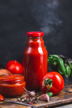 Kavanozda ketçap. Koyu arkaplanda domates sosu