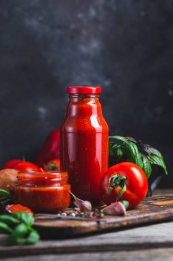 Kavanozda ketçap. Koyu arkaplanda domates sosu