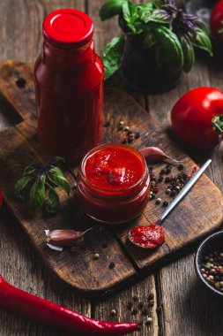 Kavanozda ketçap. Koyu arkaplanda domates sosu