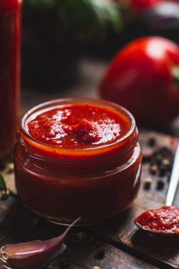 Kavanozda ketçap. Koyu arkaplanda domates sosu