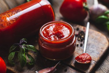 Kavanozda ketçap. Koyu arkaplanda domates sosu