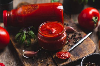 Kavanozda ketçap. Koyu arkaplanda domates sosu