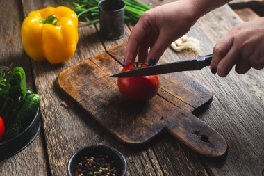 Tahtada sebze doğrayan bir kız.