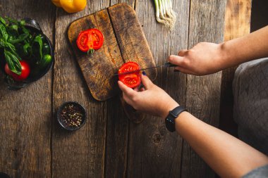 Tahtada sebze doğrayan bir kız.