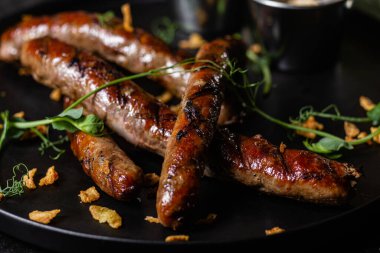 Koyu bir tabakta sosisli ızgara.