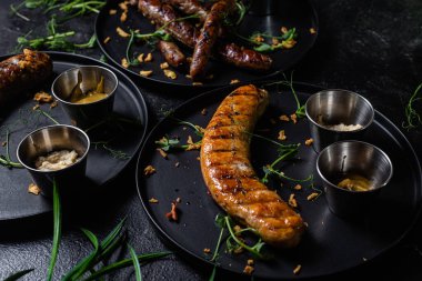 Koyu bir tabakta sosisli ızgara.